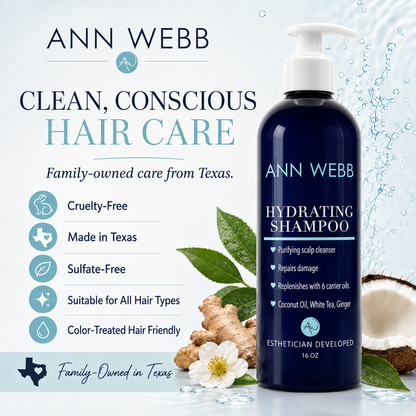 Ann Webb Hydrating Shampoo bottle on a light blue background with promotional text and icons about cruelty-free, made in Texas, sulfate-free, and suitable for all hair types. The bottle is dark blue with a white pump, surrounded by leaves, ginger root, and a white flower.