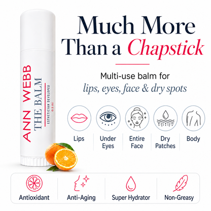 Ann Webb The Balm chapstick-style balm stick shown on a white background with promotional text, icons for lips, under eyes, entire face, dry patches, and body use, plus orange slices at the base.