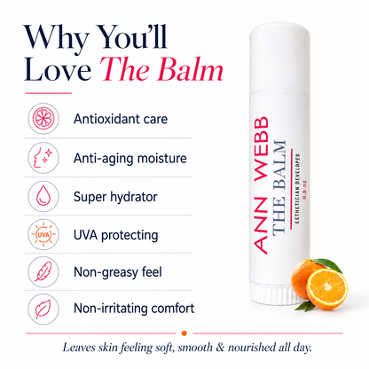 A white cosmetic balm tube labeled 'ANN WEBB THE BALM' stands on a white background beside marketing text listing benefits such as antioxidant care, anti-aging moisture, super hydration, UVA protection, non-greasy feel, and non-irritating comfort. Two orange slices appear near the base of the tube.