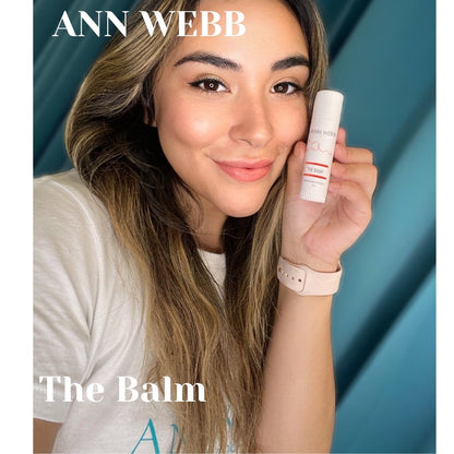 Woman applying Ann Webb The Balm multi-purpose healing balm to lips and face